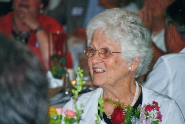 Smiling Elderly Lady holding a bouquet of flowers